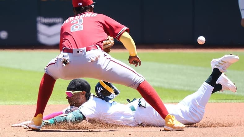 May 17, 2023; Oakland, California, USA; Oakland Athletics center fielder Esteury Ruiz (1) dives safely to second base before the ball reaches Arizona Diamondbacks shortstop Geraldo Perdomo (2) during the first inning at Oakland-Alameda County Coliseum. Mandatory Credit: Kelley L Cox-USA TODAY Sports
