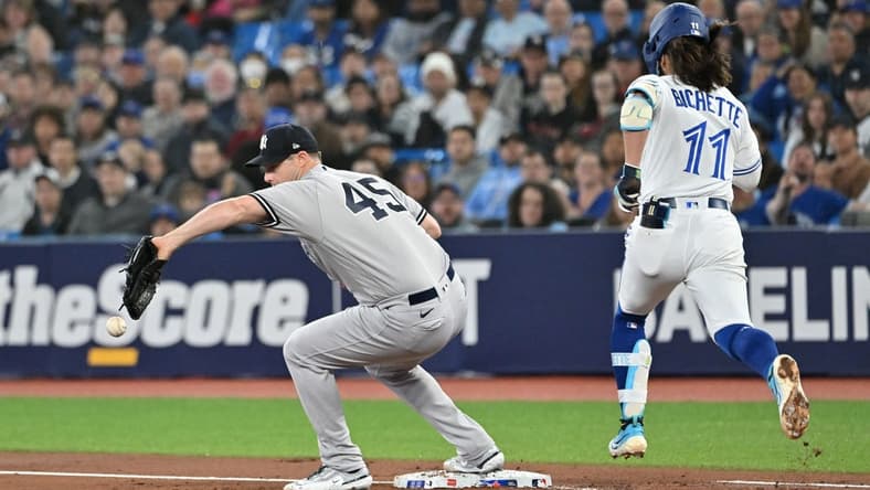 May 17, 2023; Toronto, Ontario, CAN;  New York Yankees pitcher Gerrit Cole (45) drops a throw to first base allowing Toronto Blue Jays shortstop Bo Bichette (11) to reach base safely in the first inning at Rogers Centre. Mandatory Credit: Dan Hamilton-USA TODAY Sports