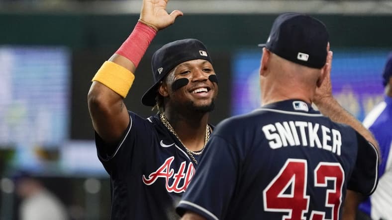 May 17, 2023; Arlington, Texas, USA; Atlanta Braves right fielder Ronald Acuna Jr. (13) high fives manager Brian Snitker (43) following a game against the Texas Rangers at Globe Life Field. Mandatory Credit: Raymond Carlin III-USA TODAY Sports