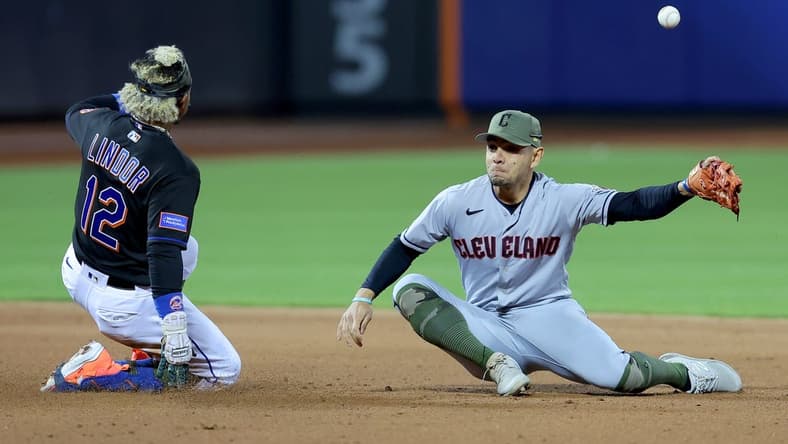 May 19, 2023; New York City, New York, USA; New York Mets shortstop Francisco Lindor (12) slides safely into second base for a double as the throw from the outfield gets away from Cleveland Guardians second baseman Andres Gimenez (0) during the fifth inning at Citi Field. Mandatory Credit: Brad Penner-USA TODAY Sports