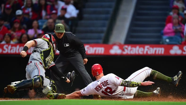 May 19, 2023; Anaheim, California, USA; Los Angeles Angels right fielder Hunter Renfroe (12) scores a run ahead of Minnesota Twins catcher Ryan Jeffers (27) during the fourth inning at Angel Stadium. Mandatory Credit: Gary A. Vasquez-USA TODAY Sports