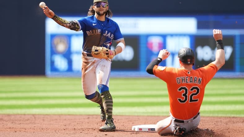 May 20, 2023; Toronto, Ontario, CAN; Toronto Blue Jays shortstop Bo Bichette (11) throws to first base after tagging out Baltimore Orioles designated hitter Ryan O'Hearn (32) at second base during the second inning at Rogers Centre. Mandatory Credit: Nick Turchiaro-USA TODAY Sports