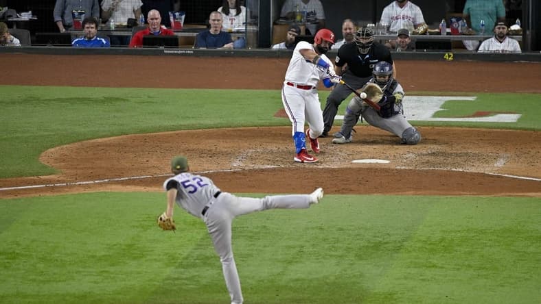 May 20, 2023; Arlington, Texas, USA; Texas Rangers catcher Sandy Leon (12) bats against Colorado Rockies relief pitcher Daniel Bard (52) during the game at Globe Life Field. Mandatory Credit: Jerome Miron-USA TODAY Sports