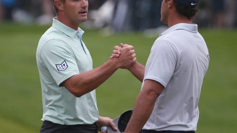 Playing partners Bryson DeChambeau and Brooks Koepka shake hands at the 18th hole following their third round at the PGA Championship at Oak Hill Country Club Saturday, May 20, 2023.  Koepka finished the day in the lead at -6, while DeChambeau finished the day in fourth at -3.