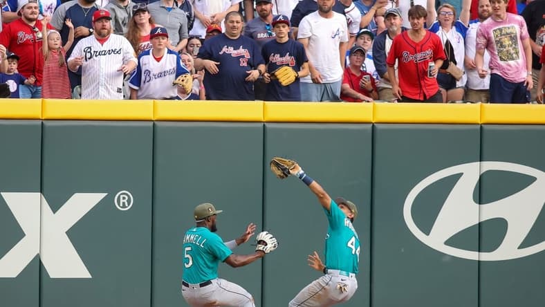 May 20, 2023; Atlanta, Georgia, USA; Seattle Mariners center fielder Julio Rodriguez (44) collides with left fielder Taylor Trammell (5) after a catch against the Atlanta Braves in the second inning at Truist Park. Mandatory Credit: Brett Davis-USA TODAY Sports
