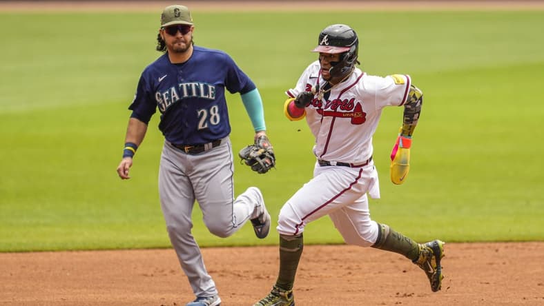 May 21, 2023; Cumberland, Georgia, USA; Atlanta Braves right fielder Ronald Acuna Jr. (13) runs past Seattle Mariners third baseman Eugenio Suarez (28) on his way to scoring a run during the first inning at Truist Park. Mandatory Credit: Dale Zanine-USA TODAY Sports