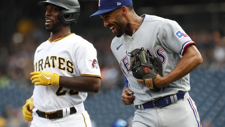 May 22, 2023; Pittsburgh, Pennsylvania, USA; Texas Rangers second baseman Marcus Semien (right) and Pittsburgh Pirates designated hitter Andrew McCutchen (22) react after McCutchen was tagged out in a rundown between third base and home plate on a double steal attempt during the first inning at PNC Park. Mandatory Credit: Charles LeClaire-USA TODAY Sports