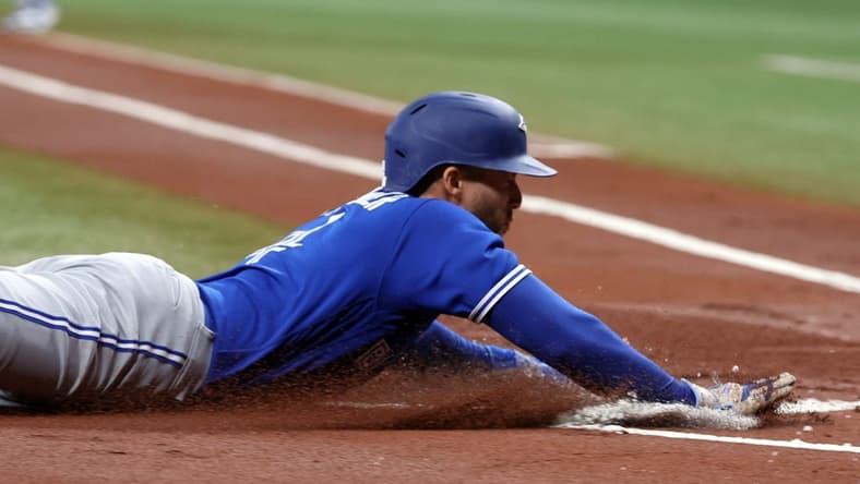 May 23, 2023; St. Petersburg, Florida, USA; Toronto Blue Jays right fielder George Springer (4) slides home to score a run against the Tampa Bay Rays during the first inning at Tropicana Field. Mandatory Credit: Kim Klement-USA TODAY Sports