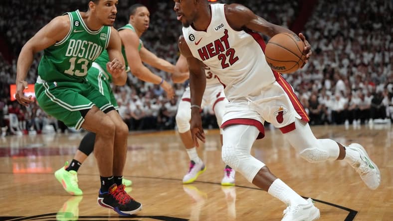 May 23, 2023; Miami, Florida, USA; Miami Heat forward Jimmy Butler (22) controls the ball against Boston Celtics guard Malcolm Brogdon (13) in the first quarter during game four of the Eastern Conference Finals for the 2023 NBA playoffs at Kaseya Center. Mandatory Credit: Jim Rassol-USA TODAY Sports