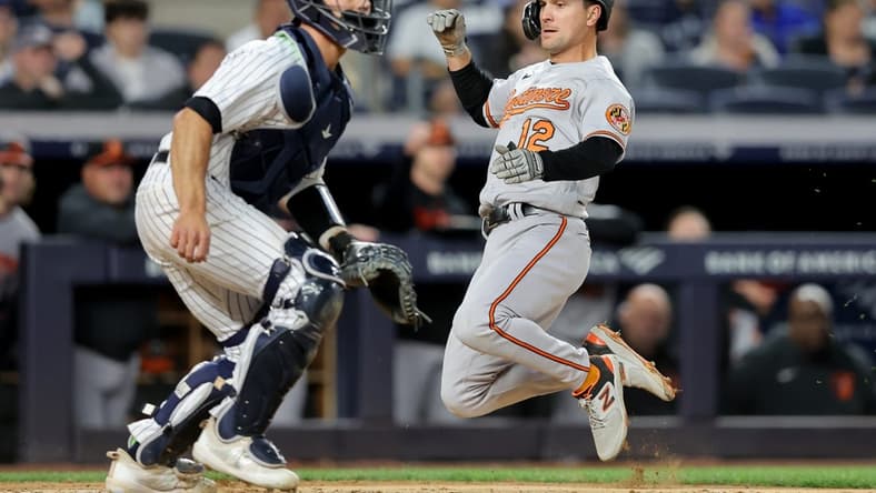 May 25, 2023; Bronx, New York, USA; Baltimore Orioles second baseman Adam Frazier (12) scores in front of New York Yankees catcher Ben Rortvedt (38) on an RBI single by Orioles right fielder Anthony Santander (not pictured) during the fifth inning at Yankee Stadium. Mandatory Credit: Brad Penner-USA TODAY Sports