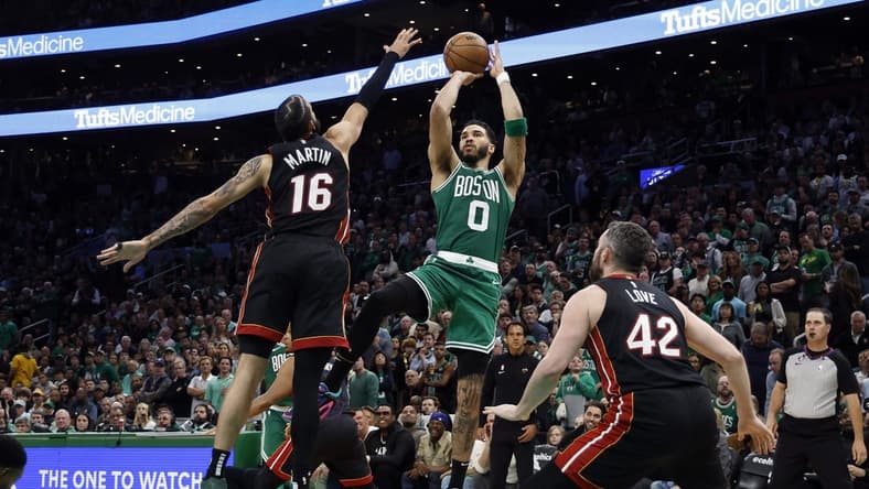 May 25, 2023; Boston, Massachusetts, USA; Boston Celtics forward Jayson Tatum (0) shoots against Miami Heat forward Caleb Martin (16) and forward Kevin Love (42) during the fourth quarter of game five of the Eastern Conference Finals for the 2023 NBA playoffs at TD Garden. Mandatory Credit: Winslow Townson-USA TODAY Sports