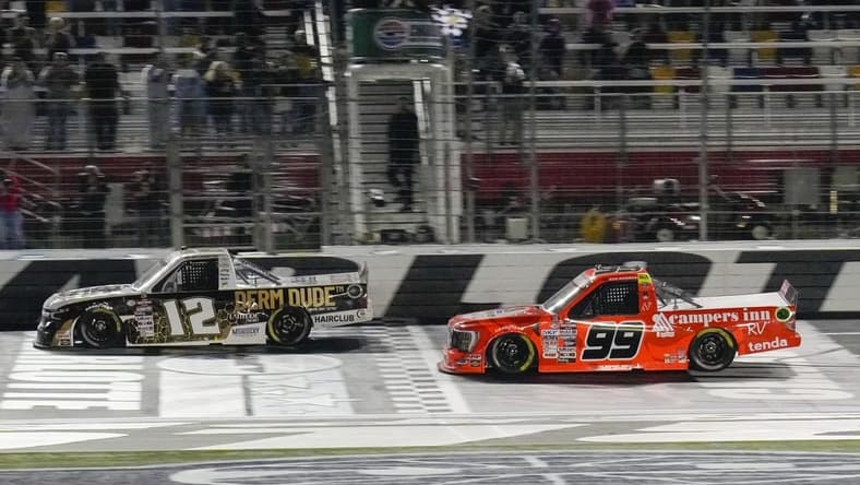 May 26, 2023; Concord, North Carolina, USA;  NASCAR Craftsman Truck Series driver Ben Rhodes (99) takes the checkered flag during the North Carolina Education Lottery 200 at Charlotte Motor Speedway. Mandatory Credit: Jim Dedmon-USA TODAY Sports