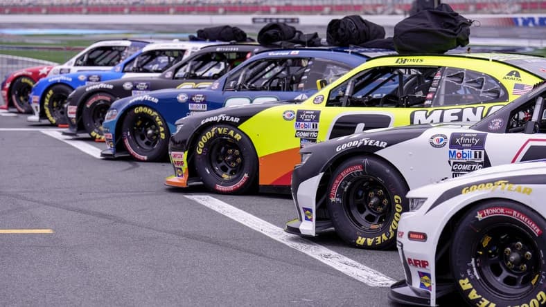 May 27, 2023; Concord, North Carolina, USA; Cars lined up in the starting grid with bagged car covers on the roofs in hopes of the rain not delaying the start during the Alsco Uniforms 300 at Charlotte Motor Speedway. Mandatory Credit: Jim Dedmon-USA TODAY Sports