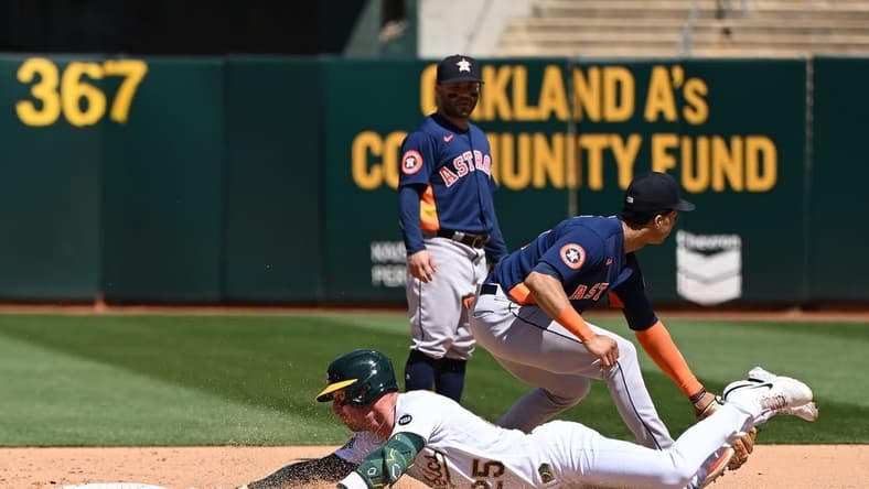 May 27, 2023; Oakland, California, USA; Oakland Athletics catcher Shea Langeliers (23) slides into second base against Houston Astros infielder Jose Altuve (27) during the eighth inning at Oakland-Alameda County Coliseum. Mandatory Credit: Robert Edwards-USA TODAY Sports