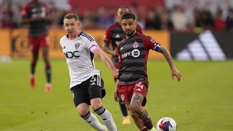 May 27, 2023; Toronto, Ontario, CAN; Toronto FC forward Lorenzo Insigne (24) fights for the ball against D.C. United midfielder Russell Canouse (6) during the first half at BMO Field. Mandatory Credit: Nick Turchiaro-USA TODAY Sports