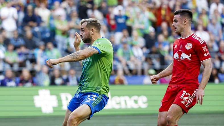 May 27, 2023; Seattle, Washington, USA; Seattle Sounders FC forward Jordan Morris (13) scores a goal against New York Red Bulls defender Dylan Nealis (12) during the first half at Lumen Field. Mandatory Credit: Joe Nicholson-USA TODAY Sports