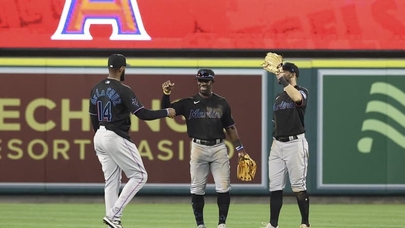 May 27, 2023; Anaheim, California, USA; Miami Marlins left fielder Bryan De La Cruz (14) and Miami Marlins center fielder Jonathan Davis (49) embrace after defeating the Los Angeles Angels 8-5 at Angel Stadium. Mandatory Credit: Jessica Alcheh-USA TODAY Sports
