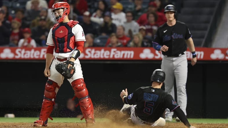 May 27, 2023; Anaheim, California, USA; Jon Berti (5) slides safely into home plate to score on an RBI single by Garrett Hampson (1) during the tenth inning of a game against the Los Angeles Angels at Angel Stadium. Mandatory Credit: Jessica Alcheh-USA TODAY Sports