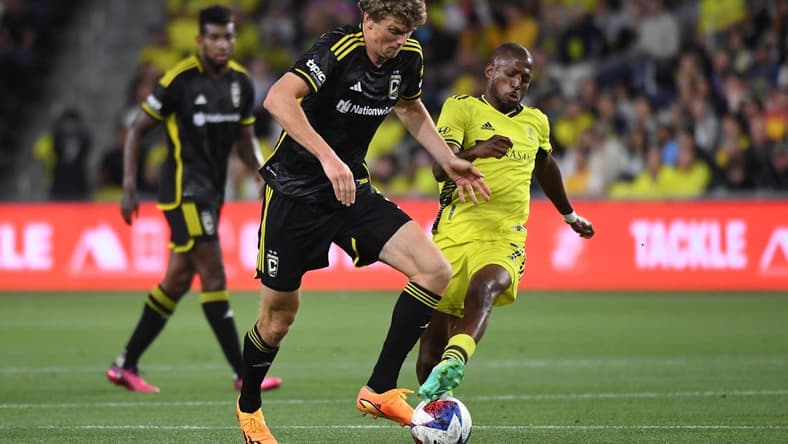 May 28, 2023; Nashville, Tennessee, USA; Nashville SC midfielder Fafa Picault (7) fights for the ball against the Columbus Crew defender Philip Quinton (2) during the first half at Geodis Park. Mandatory Credit: Christopher Hanewinckel-USA TODAY Sports