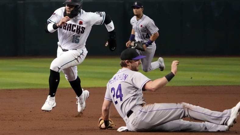 May 29, 2023; Phoenix, Arizona, USA; Arizona Diamondbacks third baseman Emmanuel Rivera (15) runs by Colorado Rockies third baseman Ryan McMahon (24)  en route to scoring a run during the second inning at Chase Field. Mandatory Credit: Joe Camporeale-USA TODAY Sports
