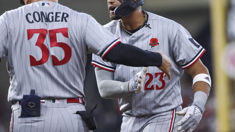 May 29, 2023; Houston, Texas, USA; Minnesota Twins third baseman Royce Lewis (23) reacts with first base/catching coach Hank Conger (35) after driving in a run with a single during the ninth inning against the Houston Astros at Minute Maid Park. Mandatory Credit: Troy Taormina-USA TODAY Sports
