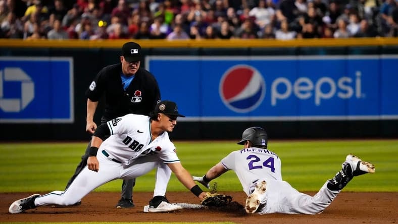 May 29, 2023; Phoenix, AZ, USA; Arizona Diamondbacks second baseman Josh Rojas (10) tags-out Colorado Rockies Ryan McMahon (24) in the second inning at Chase Field. Mandatory Credit: Rob Schumacher-Arizona Republic
