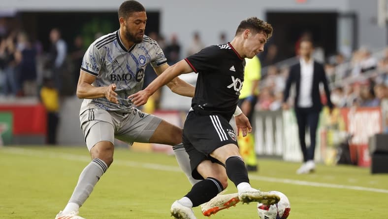 May 31, 2023; Washington, District of Columbia, USA; D.C. United midfielder Theodore Ku-DiPietro (21) dribbles the ball as CF Montr al defender George Campbell (24) defends in the first half at Audi Field. Mandatory Credit: Geoff Burke-USA TODAY Sports