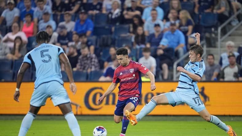 May 31, 2023; Kansas City, Kansas, USA; Sporting Kansas City midfielder Jake Davis (17) goes in for a tackle against FC Dallas forward Alan Velasco (20) during the first half at Children's Mercy Park. Mandatory Credit: Jay Biggerstaff-USA TODAY Sports