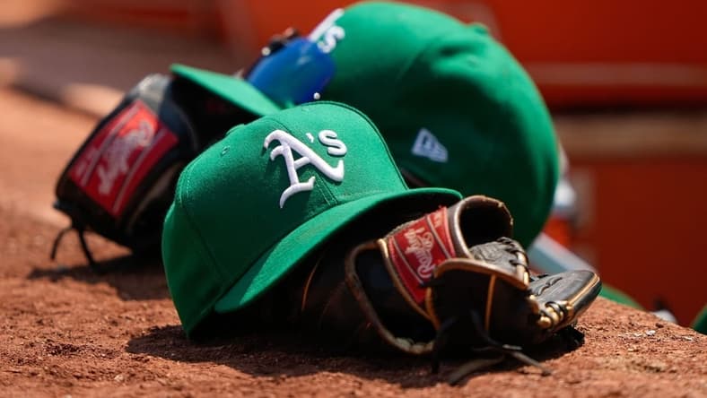 Aug 8, 2021; Oakland, California, USA; General view of the Oakland Athletics hat and glove during the fifth inning against the Texas Rangers at RingCentral Coliseum. Mandatory Credit: Stan Szeto-USA TODAY Sports
