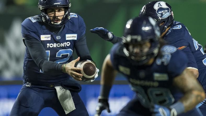 Nov 20, 2022; Regina, Saskatchewan, CAN; Toronto Argonauts quarterback Chad Kelly (12) hands the ball off to running back Andrew Harris (33) against the Winnipeg Blue Bombers in the second half. The Argonauts defeated the Blue Bombers to win the 2022 Grey Cup Championship at Mosaic Stadium. Toronto won 24-23. Mandatory Credit: Bob Frid-USA TODAY Sports