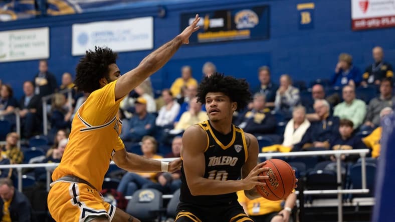 Toledo guard RayJ Dennis looks for an open teammate under the basket while being guarded by Kent State guard Sincere Carry during an NCAA basketball game, Tuesday, Jan. 10, 2023 at the Kent State M.A.C. Center.

University Of Toledo Rockets At Kent State Golden Flashes Ncaa Men S Basketball