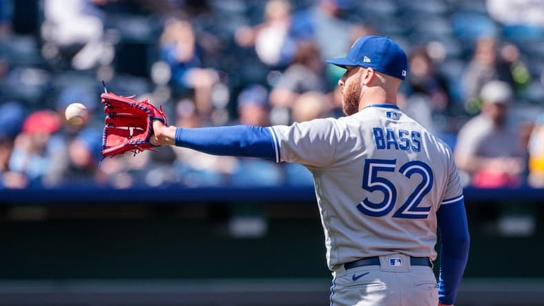Apr 6, 2023; Kansas City, Missouri, USA; Toronto Blue Jays relief pitcher Anthony Bass (52) reaches for a throw during the seventh inning against the Kansas City Royals at Kauffman Stadium. Mandatory Credit: William Purnell-USA TODAY Sports