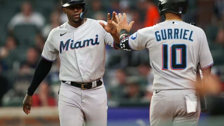 Apr 25, 2023; Atlanta, Georgia, USA; Miami Marlins designated hitter Jorge Soler (12) celebrates after scoring with first baseman Yuli Gurriel (10) against the Atlanta Braves in eighth inning at Truist Park. Mandatory Credit: Brett Davis-USA TODAY Sports