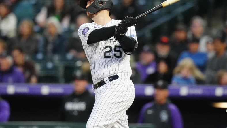 May 12, 2023; Denver, Colorado, USA; Colorado Rockies first baseman C.J. Cron (25) hits a RBI sacrifice fly in the sixth inning against the Philadelphia Phillies at Coors Field. Mandatory Credit: Ron Chenoy-USA TODAY Sports