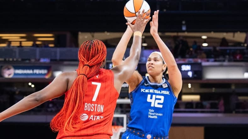 May 19, 2023; Indianapolis, Indiana, USA; Connecticut Sun center Brionna Jones (42) shoots the ball while Indiana Fever forward Aliyah Boston (7) defends in the first half at Gainbridge Fieldhouse. Mandatory Credit: Trevor Ruszkowski-USA TODAY Sports