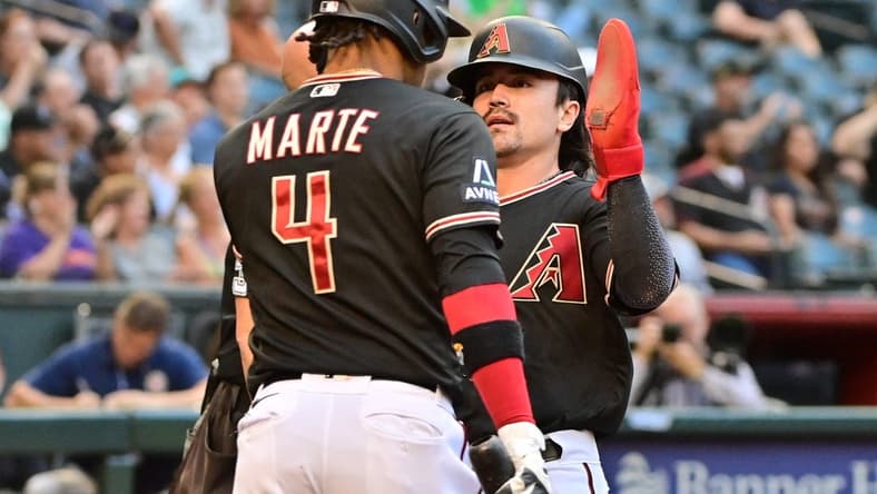 May 31, 2023; Phoenix, Arizona, USA; Arizona Diamondbacks left fielder Corbin Carroll (7) celebrates with second baseman Ketel Marte (4) after scoring in the first inning against the Colorado Rockies at Chase Field. Mandatory Credit: Matt Kartozian-USA TODAY Sports