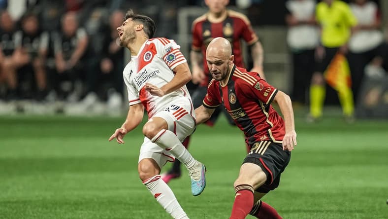 May 31, 2023; Atlanta, Georgia, USA; New England Revolution midfielder Carles Gil (10) reacts after a play on the ball by Atlanta United defender Andrew Gutman (15) during the second half at Mercedes-Benz Stadium. Mandatory Credit: Dale Zanine-USA TODAY Sports