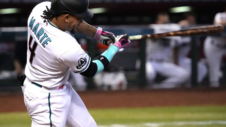 Jun 1, 2023; Phoenix, Arizona, USA; Arizona Diamondbacks second baseman Ketel Marte (4) hits an RBI double against the Colorado Rockies during the seventh inning at Chase Field. Mandatory Credit: Joe Camporeale-USA TODAY Sports