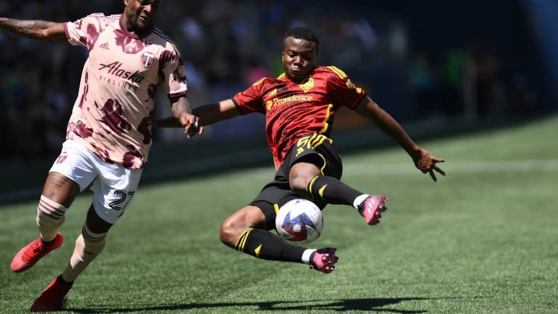 Jun 3, 2023; Seattle, WA, USA; Seattle Sounders defender Nouhou Tolo (5) clears the ball away from Portland Timbers forward Dairon Asprilla (27) in a MLS game at Lumen Field. Mandatory Credit: Steven Bisig-USA TODAY Sports