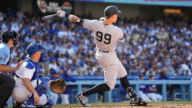 Jun 3, 2023; Los Angeles, California, USA; New York Yankees right fielder Aaron Judge (99) follows through on a home run in the sixth inning as Los Angeles Dodgers catcher Will Smith (16) and home plate umpire John Tumpane (74) watch at Dodger Stadium. Mandatory Credit: Kirby Lee-USA TODAY Sports