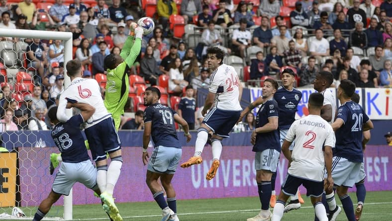 Jun 3, 2023; Vancouver, British Columbia, CAN;  Sporting Kansas City goalkeeper Kendall McIntosh (22) reaches for the ball as Vancouver Whitecaps FC forward Brian White (24) looks to head the ball during the first half at BC Place. Mandatory Credit: Anne-Marie Sorvin-USA TODAY Sports