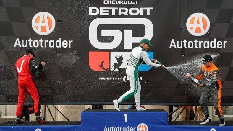Detroit Grand Prix winner Alex Palou, center, second place Will Power, left, and third place Felix Rosenqvist celebrate their top three finish with champagne in Detroit on Sunday, June 4, 2023.