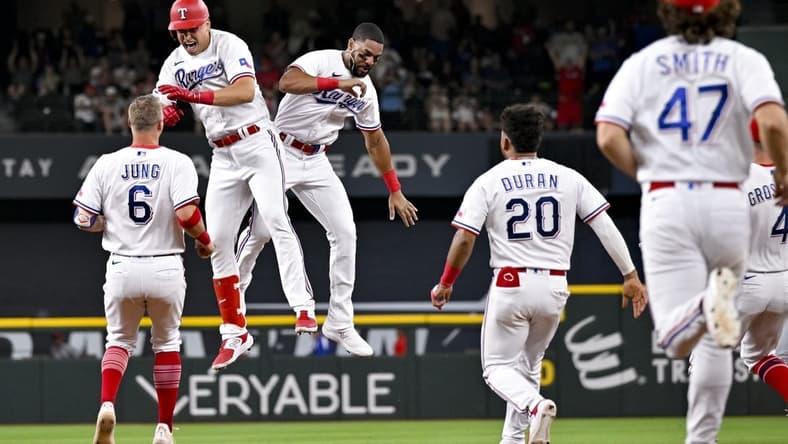 Jun 5, 2023; Arlington, Texas, USA; The Texas Rangers run on to the field after first baseman Nathaniel Lowe (30) drives in the game winning run against the St. Louis Cardinals during the ninth inning at Globe Life Field. Mandatory Credit: Jerome Miron-USA TODAY Sports
