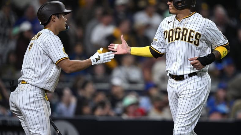 Jun 5, 2023; San Diego, California, USA; San Diego Padres third baseman Manny Machado (13) is congratulated by shortstop Ha-seong Kim (7) after scoring a run against the Chicago Cubs during the eighth inning at Petco Park. Mandatory Credit: Orlando Ramirez-USA TODAY Sports