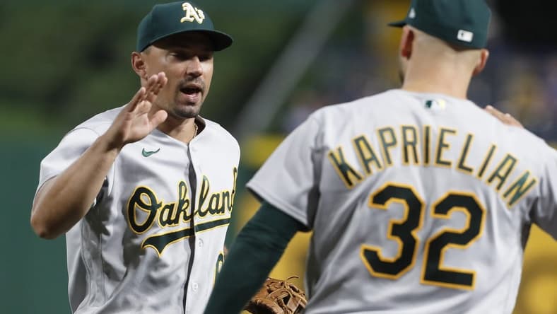 Jun 6, 2023; Pittsburgh, Pennsylvania, USA; Oakland Athletics second baseman Jace Peterson (left) and starting pitcher James Kaprielian (32) celebrate after defeating the Pittsburgh Pirates at PNC Park. Oakland won 11-2.  Mandatory Credit: Charles LeClaire-USA TODAY Sports