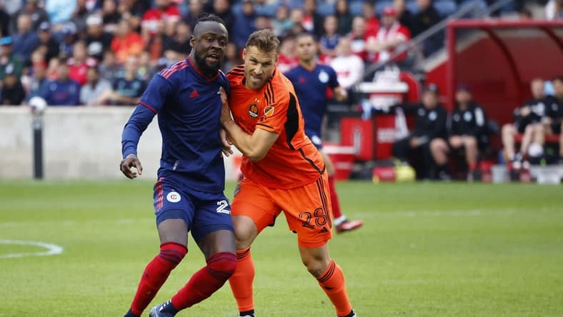 Jun 6, 2023; Bridgeview, IL, USA; Chicago Fire forward Kei Kamara (23) kicks the ball past Houston Dynamo defender
Erik Sviatchenko (28) during the first half at SeatGeek Stadium. Mandatory Credit: Mike Dinovo-USA TODAY Sports
