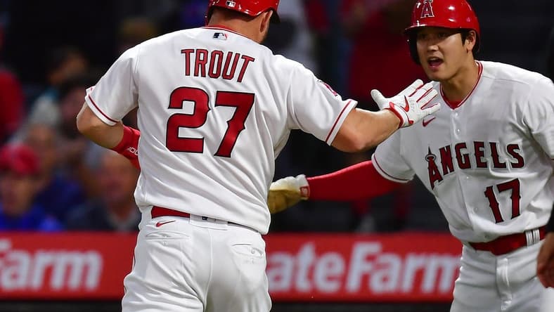 Jun 6, 2023; Anaheim, California, USA; Los Angeles Angels center fielder Mike Trout (27) is greeted by designated hitter Shohei Ohtani (17) after scoring a run against the Chicago Cubs during the fifth inning at Angel Stadium. Mandatory Credit: Gary A. Vasquez-USA TODAY Sports
