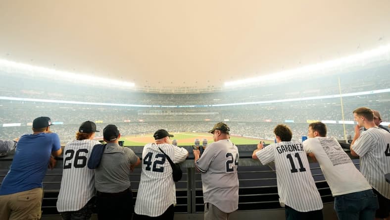 Yankee fans watch the game against the White Sox as a thick haze from the Canadian wildfires hover over the Bronx on June 6, 2023.