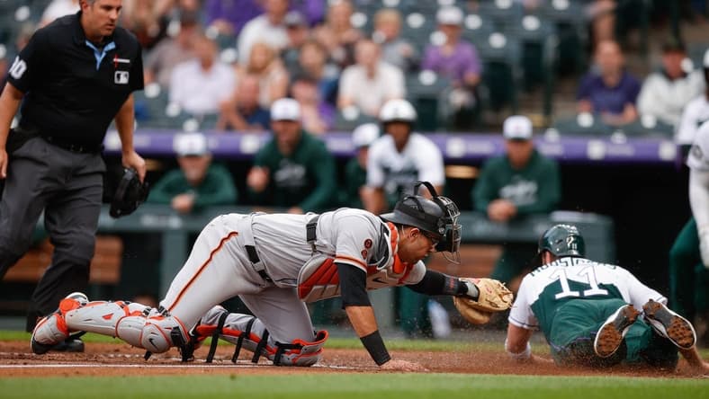 Jun 7, 2023; Denver, Colorado, USA; Colorado Rockies first baseman Mike Moustakas (11) slides safely home ahead of the tag from San Francisco Giants catcher Blake Sabol (2) in the second inning at Coors Field. Mandatory Credit: Isaiah J. Downing-USA TODAY Sports