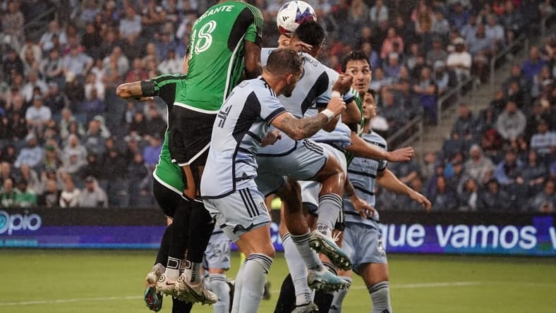 Jun 10, 2023; Kansas City, Kansas, USA; Austin FC defender Julio Cascante (18) heads the ball against Sporting Kansas City defender Robert Castellanos (19) during the first half at Children's Mercy Park. Mandatory Credit: Denny Medley-USA TODAY Sports